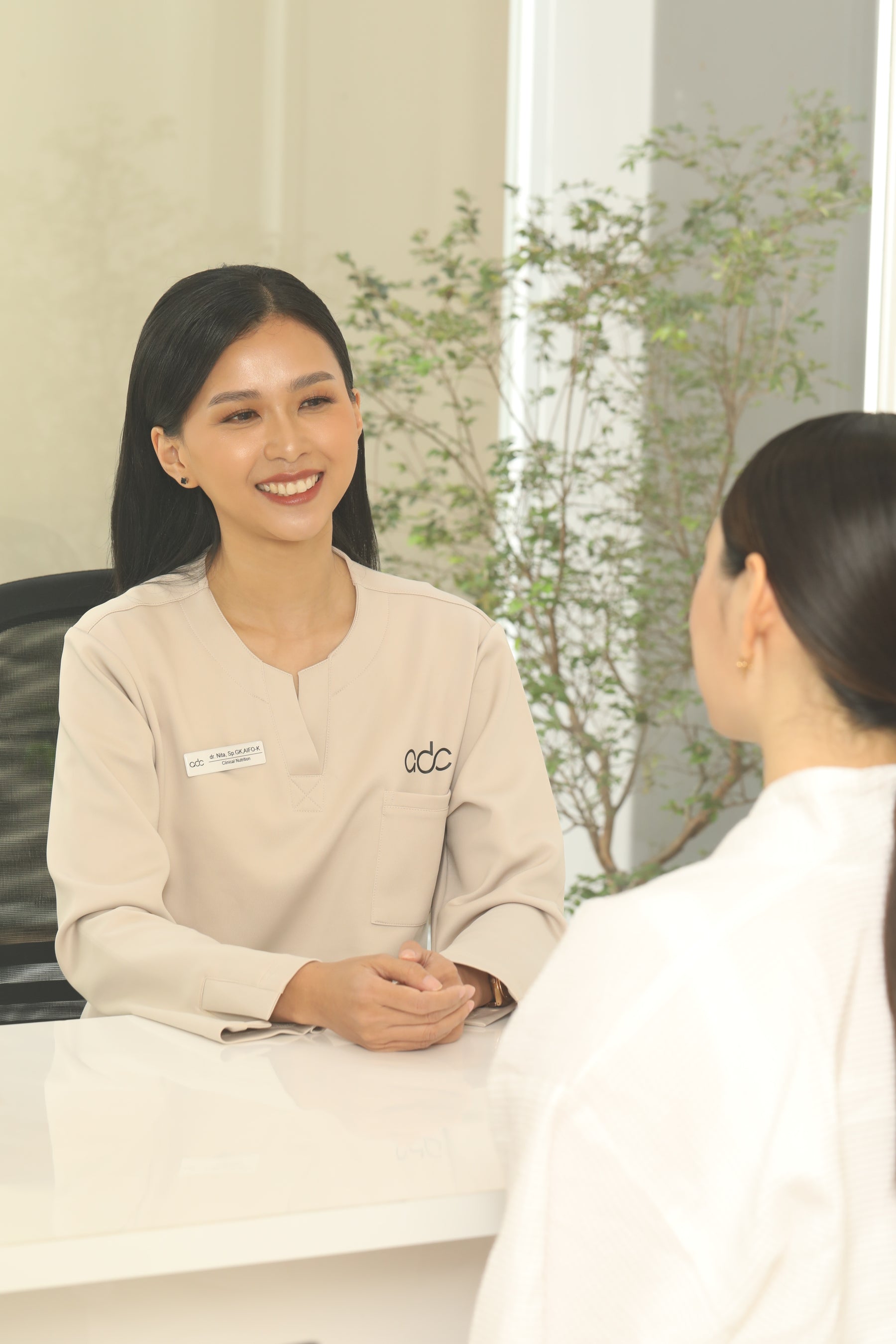 Promil Treatment clinician wearing beige scrub top with name badge