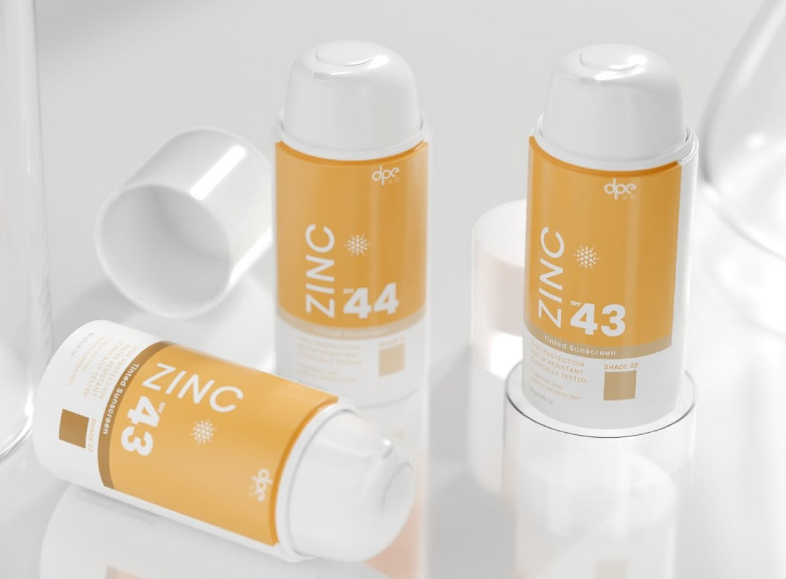 Zinc tinted sunscreen spray canister, shades 44 and 43, orange label with SPF text