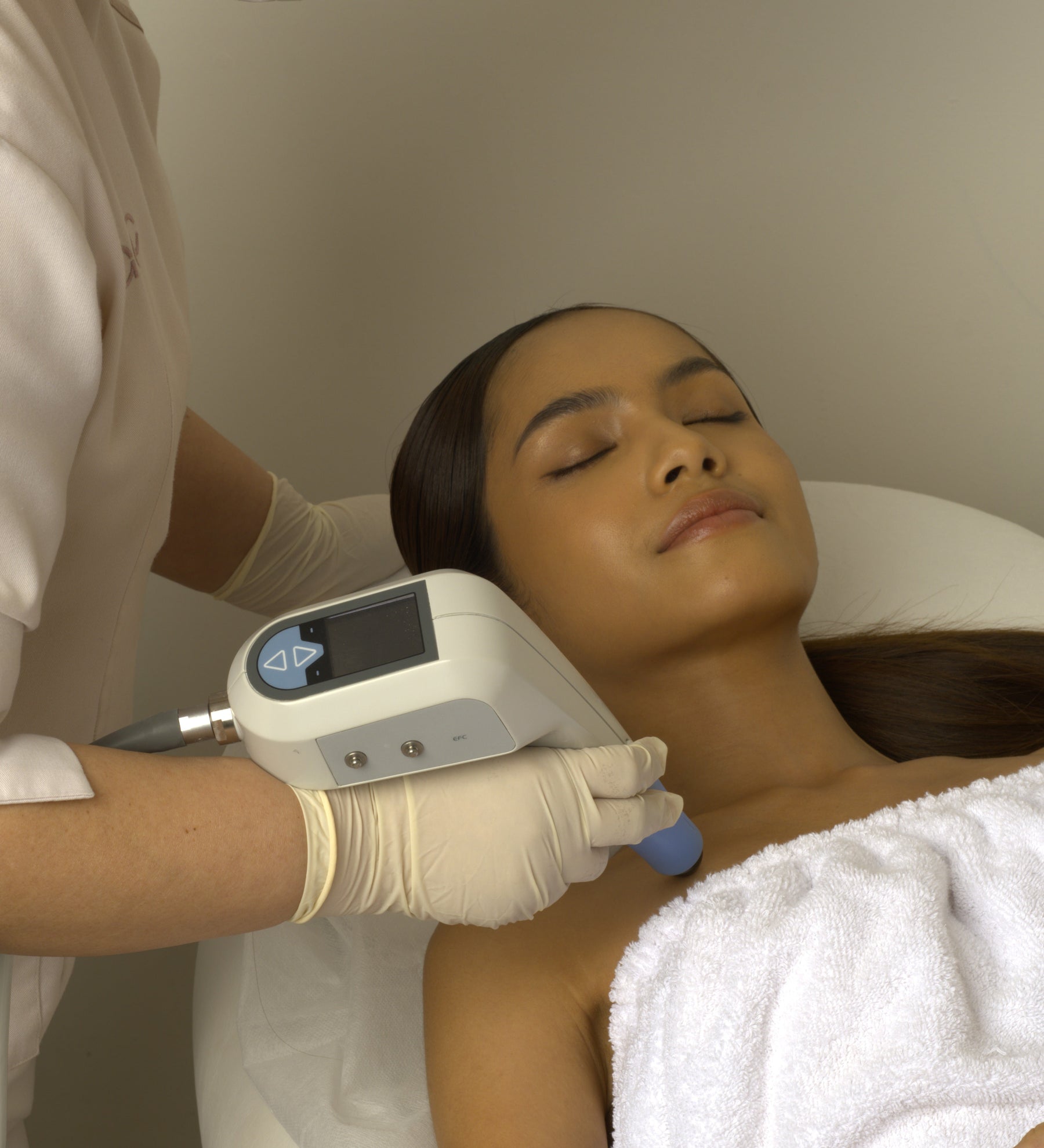 ExiPro handheld skincare device with digital display, gloved hand applying on shoulder