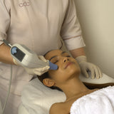 Person receiving an Exilis Ultra 360 facial treatment with a device in a clinic setting