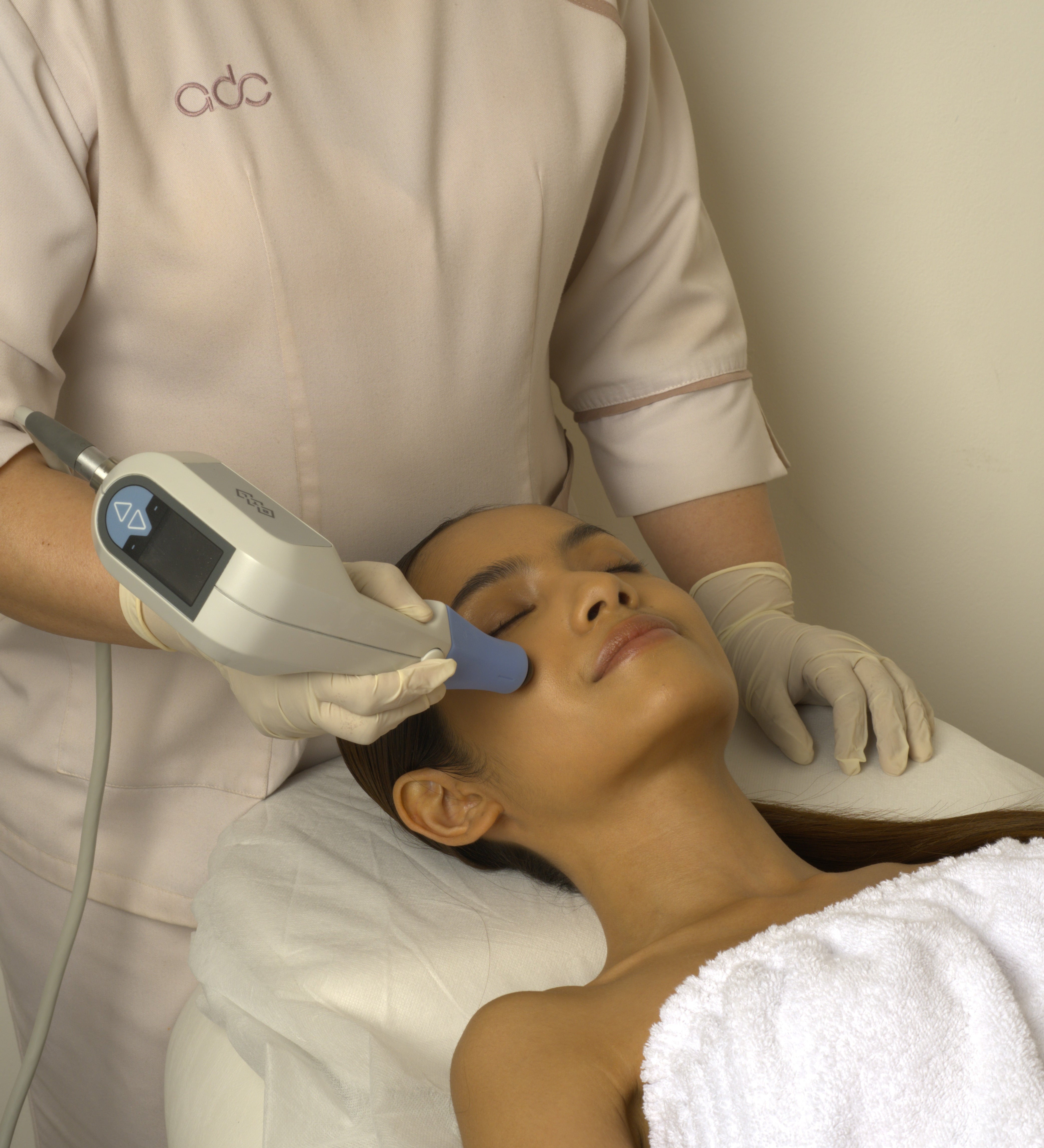 Person receiving an Exilis Ultra 360 facial treatment with a device in a clinic setting
