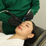Person receiving Eye Bag Removal, wearing green coat.