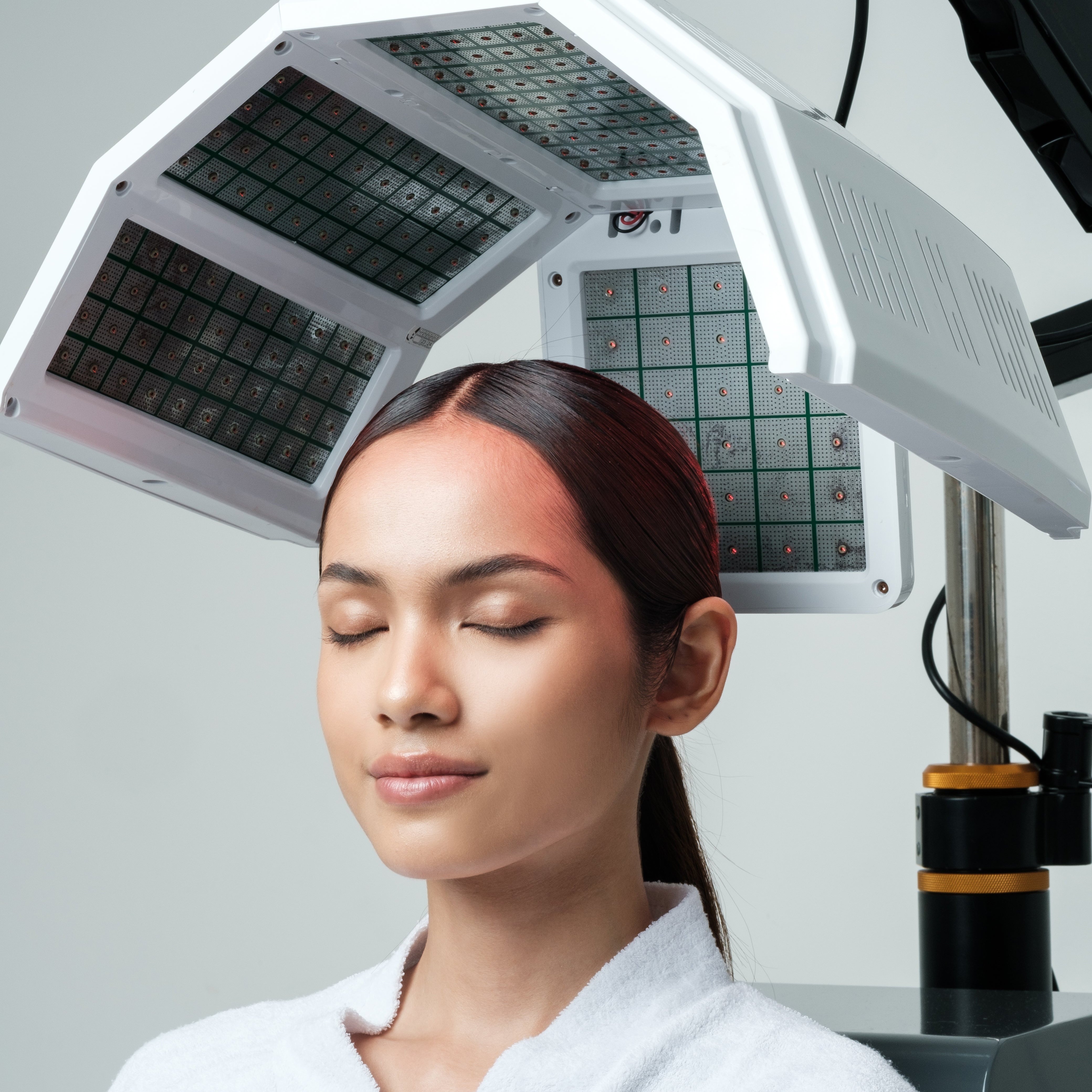 A woman is being treated with Hair Growth Laser