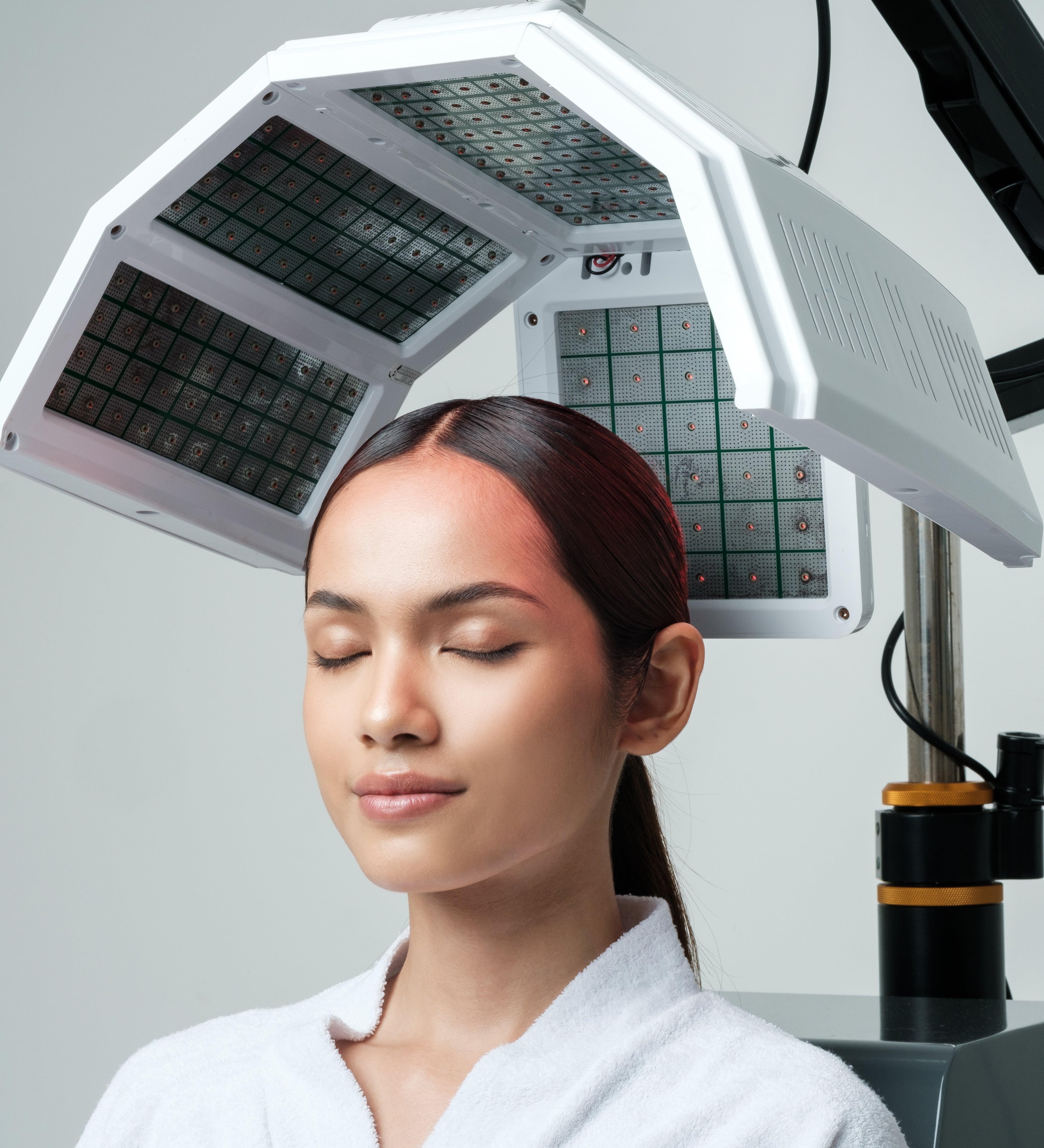 A woman is being treated with Hair Growth Laser