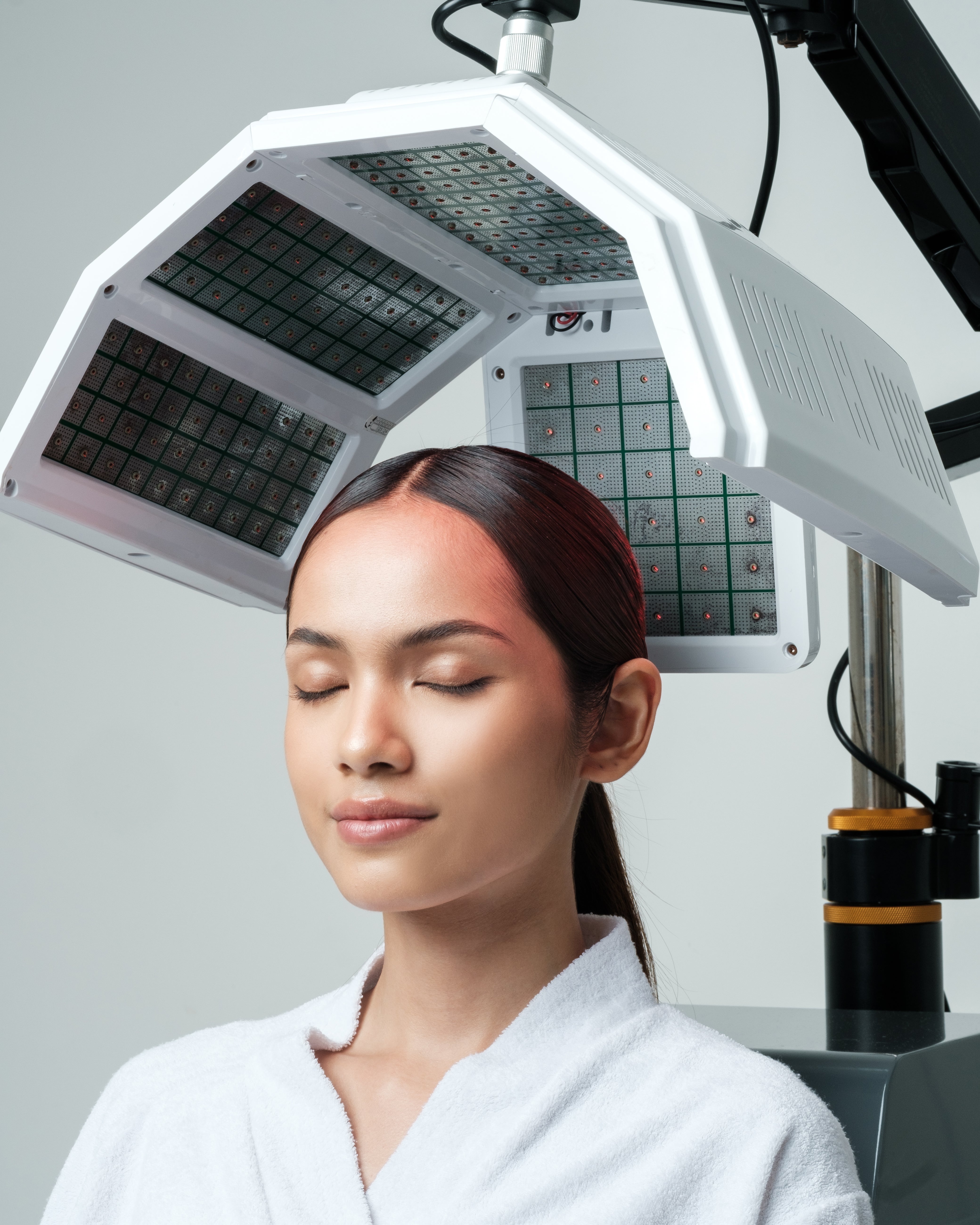 A woman is being treated with Hair Growth Laser
