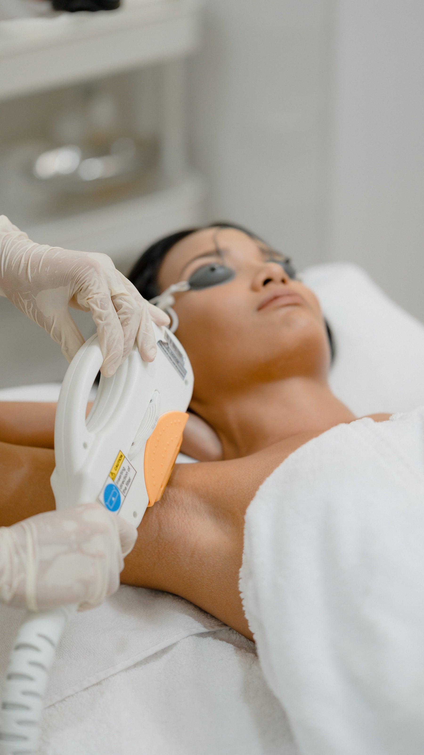 Handheld IPL hair removal device with light window, used on neck