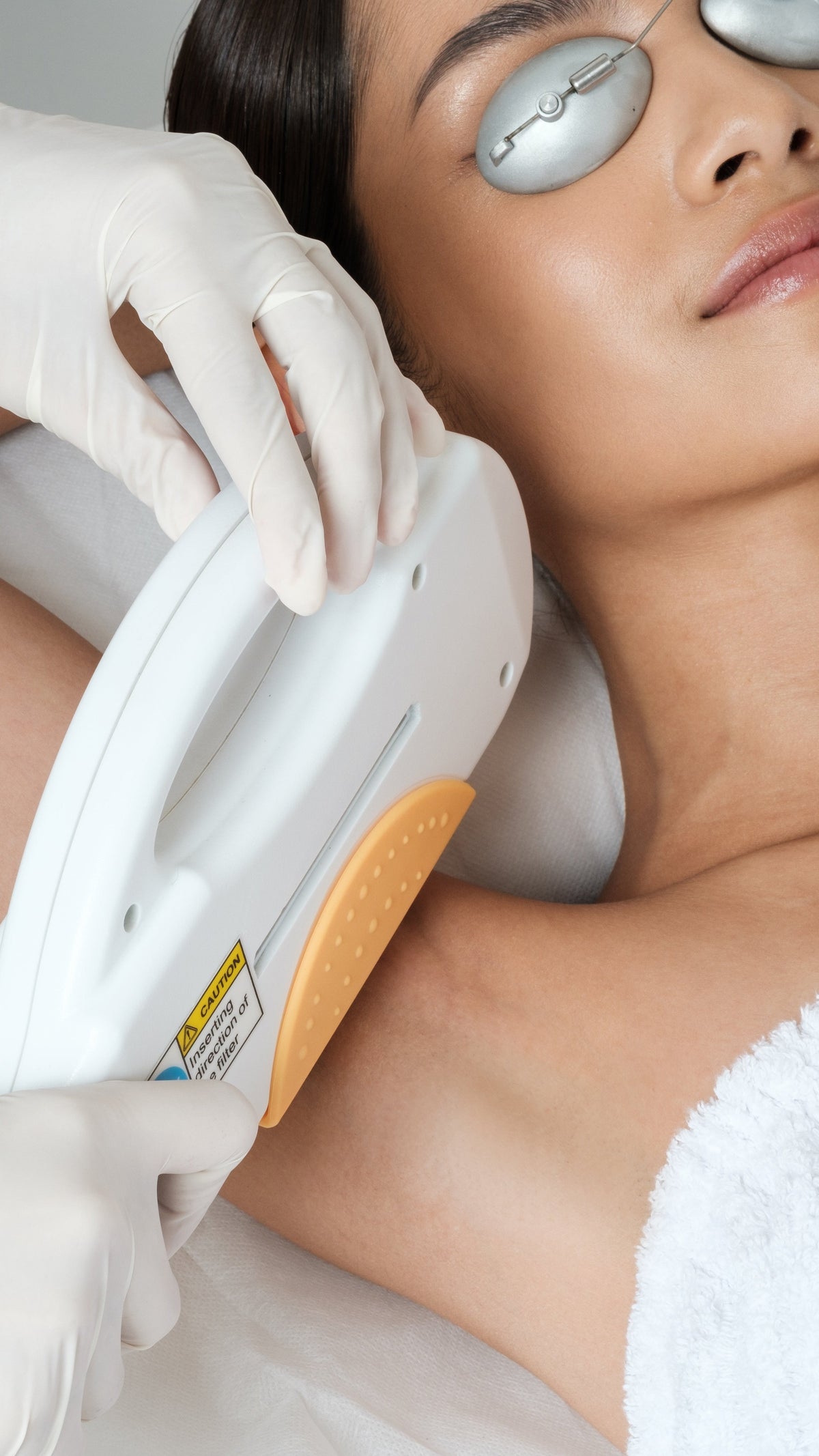 IPL hair removal device in gloved hands treating skin on neck