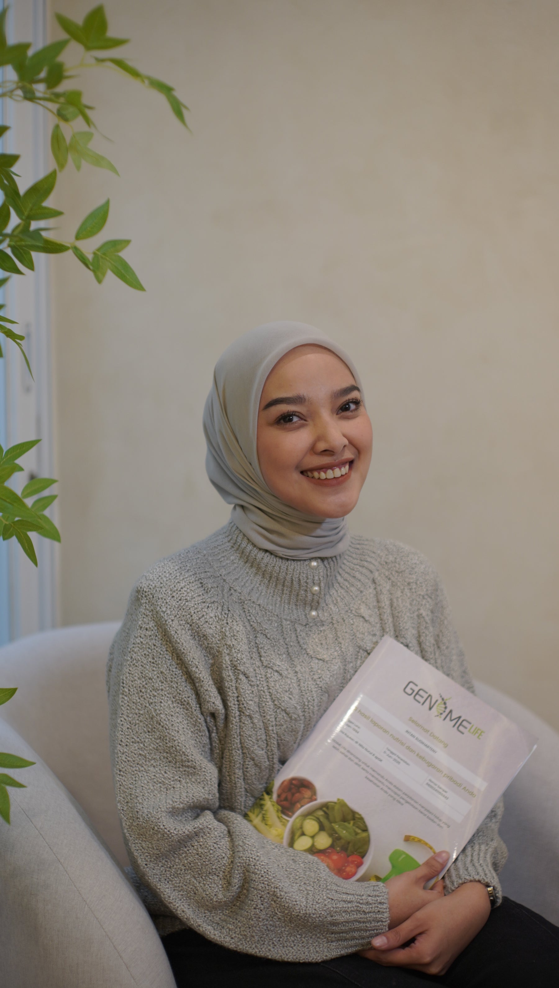 Nutrigenomic branded booklet and box held by person in light knit sweater